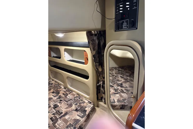 Slide: The Image of Interior cabin of 2003 Rinker Fiesta Vee 270 boat with patterned upholstery and storage compartments. - 25