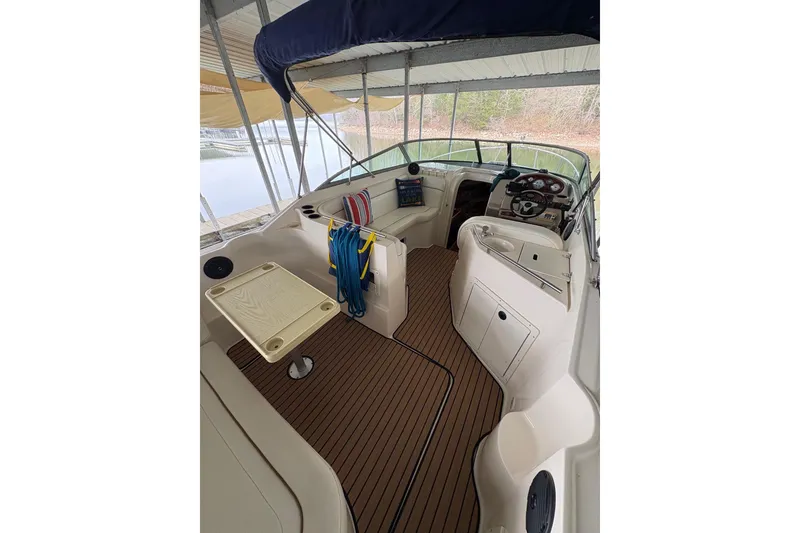 Slide: The Image of 2003 Rinker Fiesta Vee 270 boat interior with seating, table, and steering console. - 28