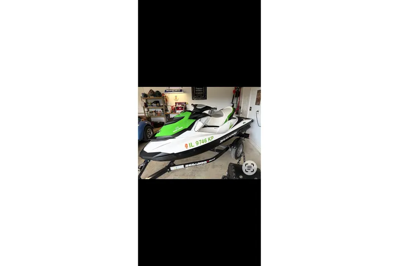 Slide: The Image of A green and white Sea-Doo jet ski on a trailer in a garage. - 30