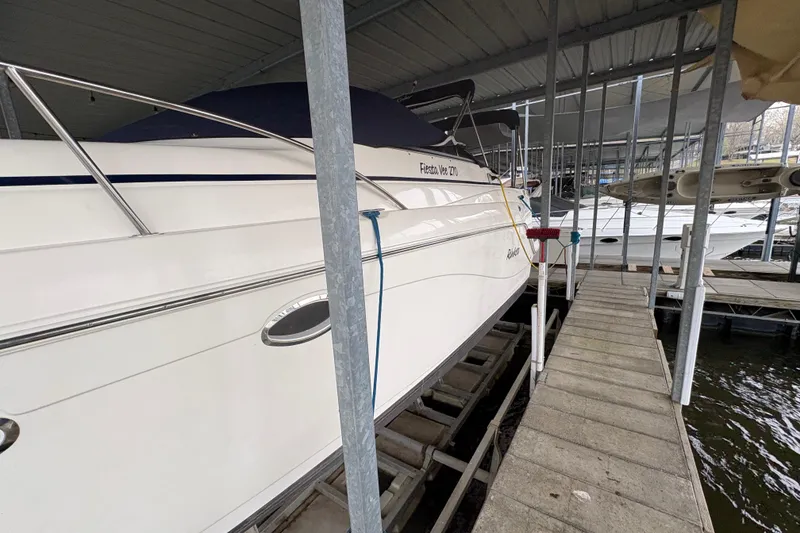 Slide: The Image of 2003 Rinker Fiesta Vee 270 boat docked in a covered marina. - 6