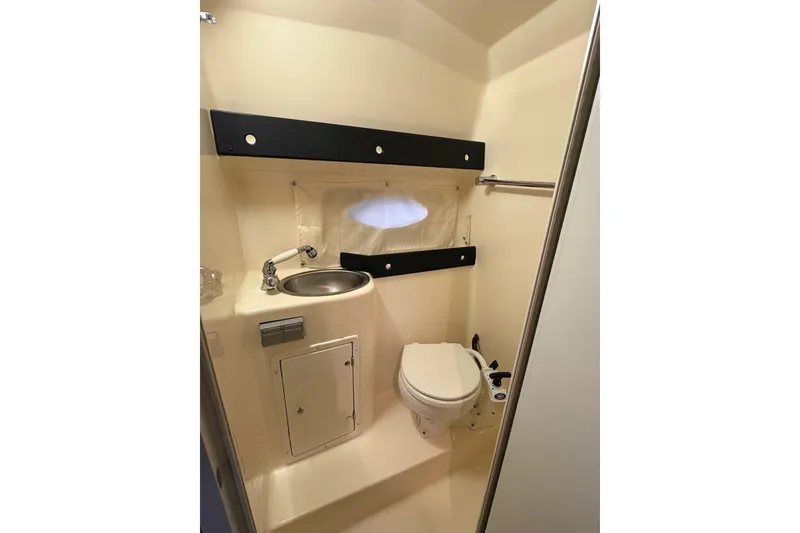 Slide: The Image of 2003 Rinker Fiesta Vee 270 boat bathroom with sink, toilet, and storage cabinet. - 17