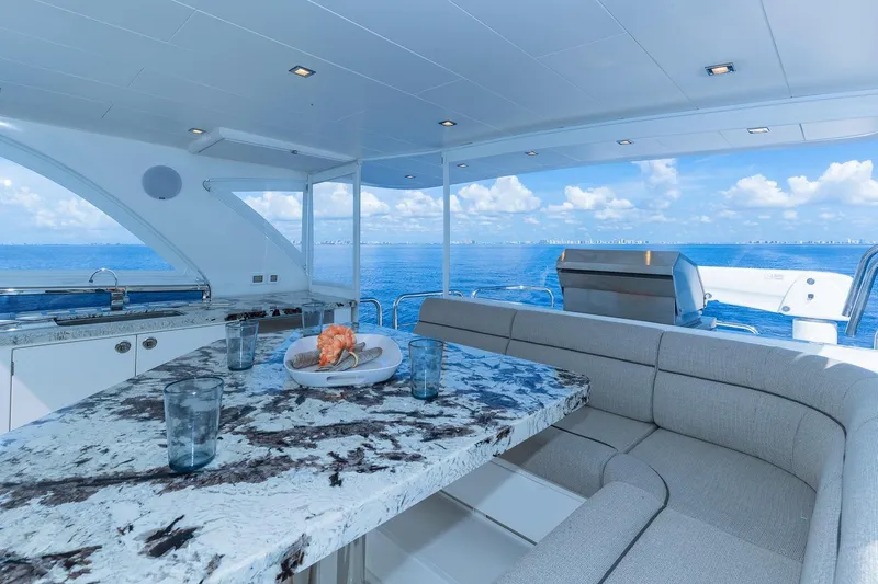 Slide: The Image of Luxurious Regency P65 yacht interior with marble table, ocean view, and modern seating, 2019 model. - 16