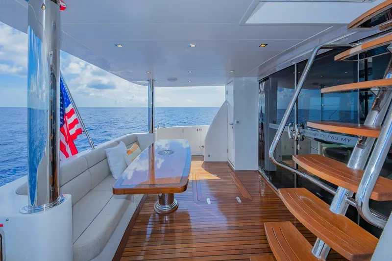 Slide: The Image of Luxurious 2019 Regency P65 yacht deck with seating, table, and ocean view. - 23