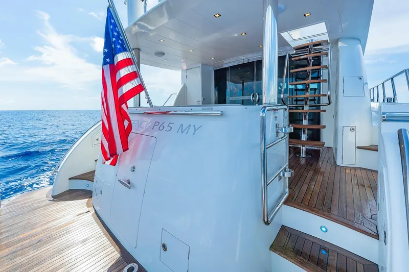 Slide: The Image of Luxury 2019 Regency P65 yacht with American flag, wooden deck, and ocean view. - 26
