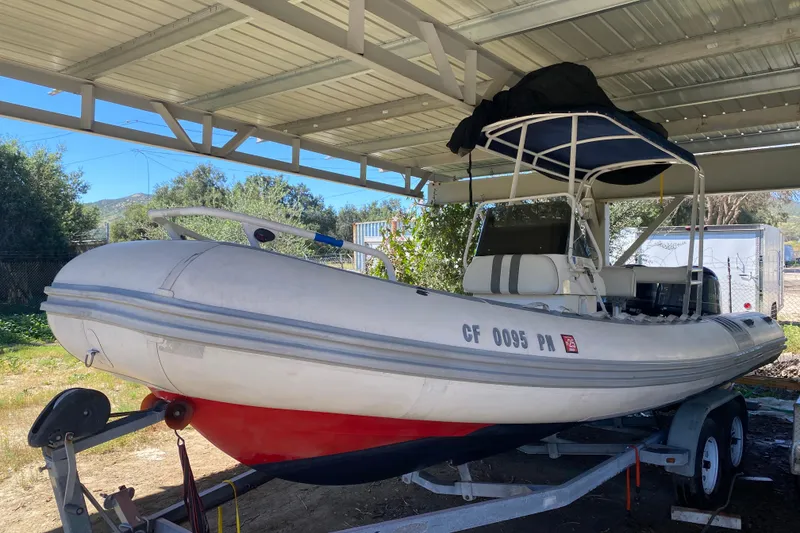 Slide: The Image of 2000 Novurania 21 inflatable boat on trailer under metal canopy. - 1