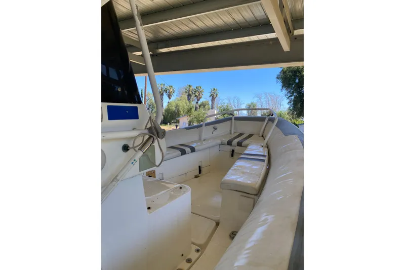 Slide: The Image of Interior view of a 2000 Novurania 21 boat under a metal canopy, featuring cushioned seating. - 12