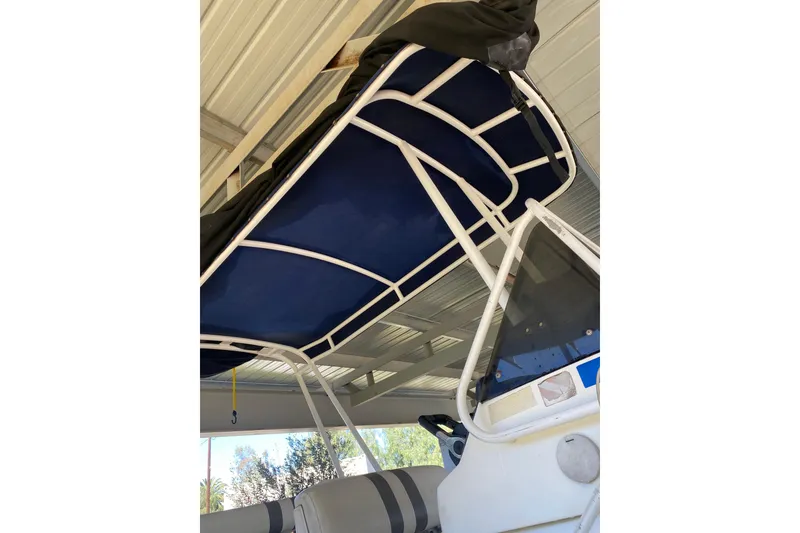 Slide: The Image of Novurania 21 boat (2000) with blue canopy and white frame under shelter. - 14