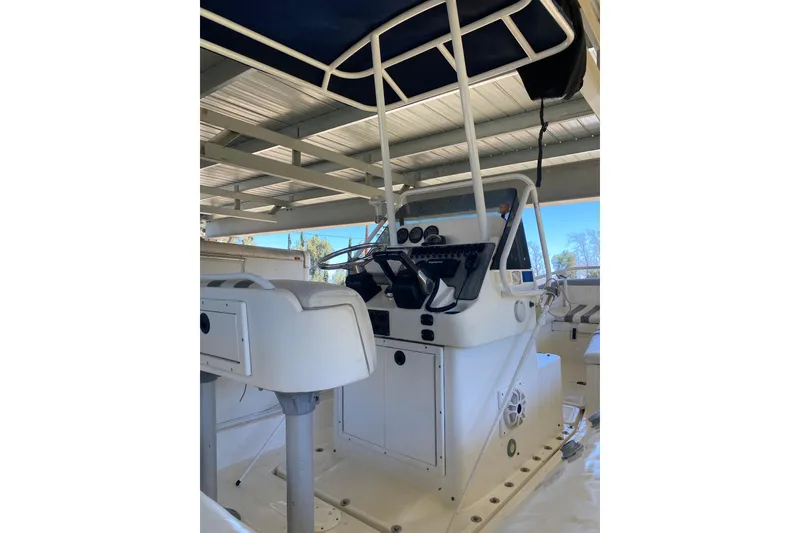 Slide: The Image of 2000 Novurania 21 boat interior with steering console and seating under a canopy. - 9