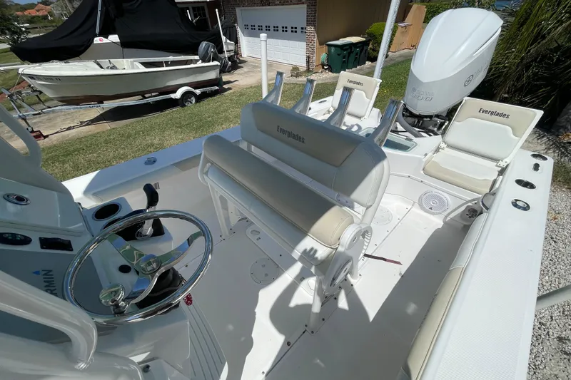 Slide: The Image of 2017 Everglades 243 Center Console boat with seating and steering wheel, parked outdoors. - 12