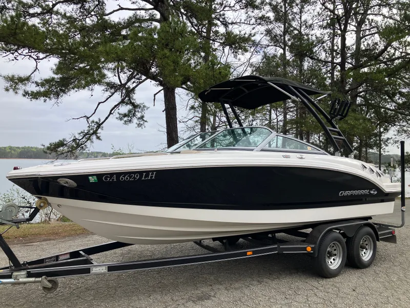 Slide: The Image of 2011 Chaparral 216 SSi boat on trailer, surrounded by trees. - 1