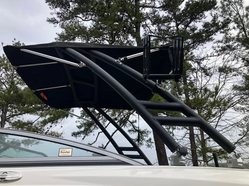 Slide: The Image of 2011 Chaparral 216 SSi boat with black canopy and trees in background. - 25