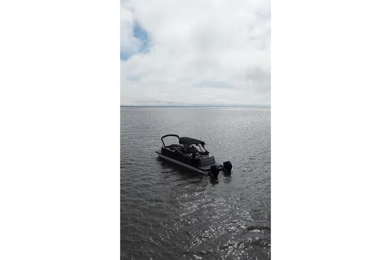 Slide: The Image of 2022 Avalon Catalina Platinum Cruise pontoon boat on calm water under cloudy sky. - 3