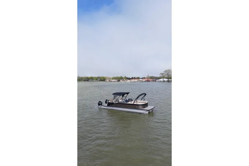 Slide: The Image of 2022 Avalon Catalina Platinum Cruise pontoon boat on a calm lake under a clear sky. - 49