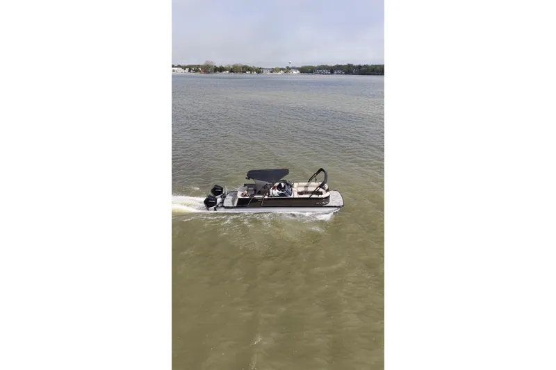 Slide: The Image of 2022 Avalon Catalina Platinum Cruise pontoon boat cruising on a calm lake. - 56