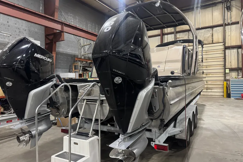 Slide: The Image of 2022 Avalon Catalina Platinum Cruise boat with dual Mercury engines in a warehouse setting. - 2