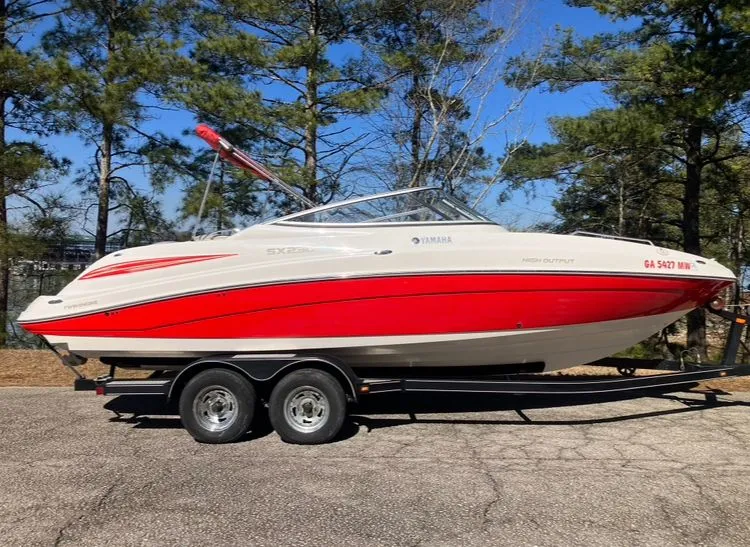 Slide: The Image of 2009 Yamaha SX230 boat on trailer, red and white, parked outdoors. - 4