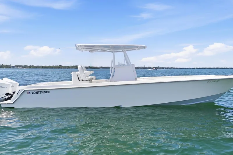 The Image of 2024 Contender 32 ST boat on calm water under clear blue sky. - 1