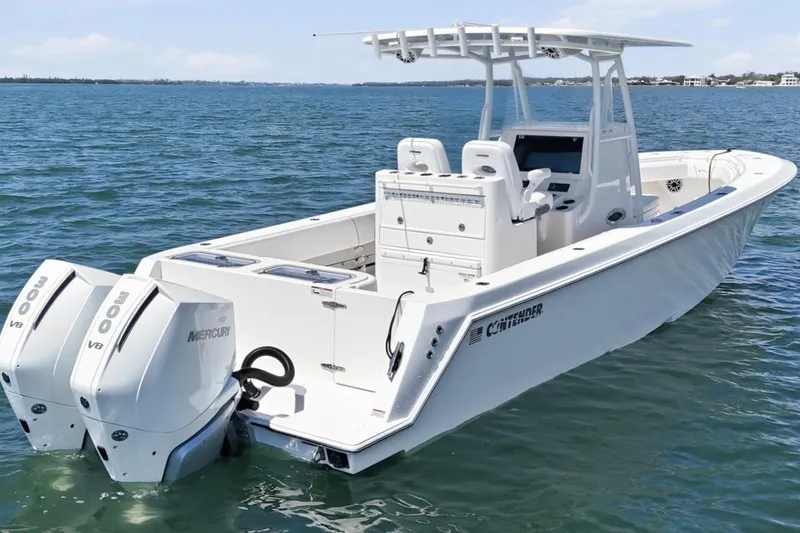 Slide: The Image of 2024 Contender 32 ST boat with dual Mercury V8 engines on open water. - 2