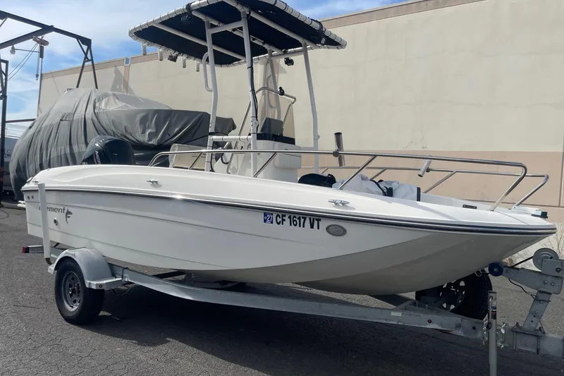 Slide: The Image of 2020 Bayliner Element F18 boat on trailer, parked outdoors. - 2