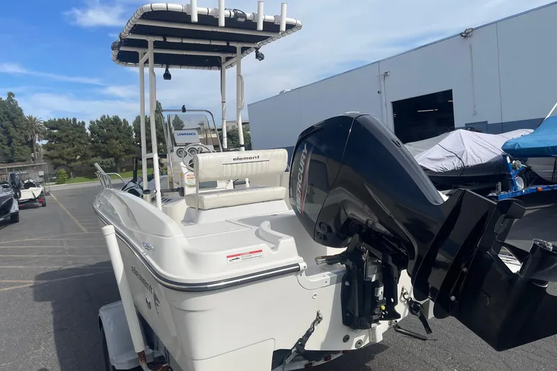 Slide: The Image of 2020 Bayliner Element F18 boat with Mercury outboard motor in a parking lot. - 3