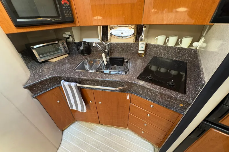 Slide: The Image of Compact kitchen in 2004 Formula 41 Performance Cruiser with modern appliances and wooden cabinetry. - 16