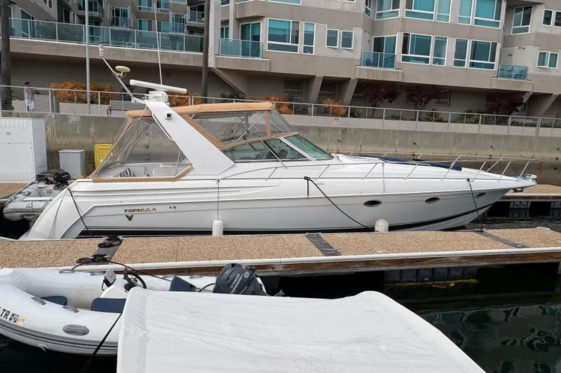 Slide: The Image of 2004 Formula 41 Performance Cruiser docked near modern waterfront apartments. - 2