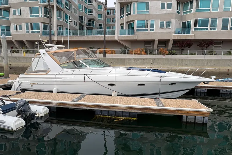 Slide: The Image of 2004 Formula 41 Performance Cruiser docked near modern waterfront apartments. - 3