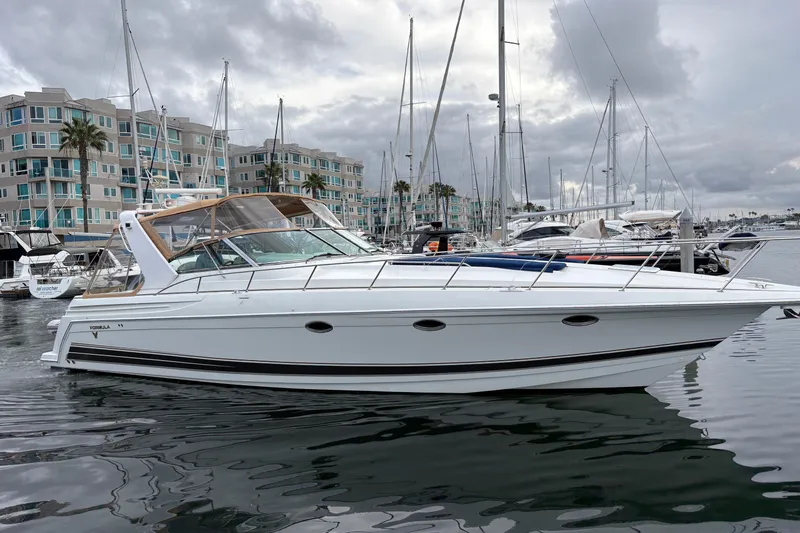 Slide: The Image of 2004 Formula 41 Performance Cruiser yacht docked in marina, overcast sky, modern buildings in background. - 37