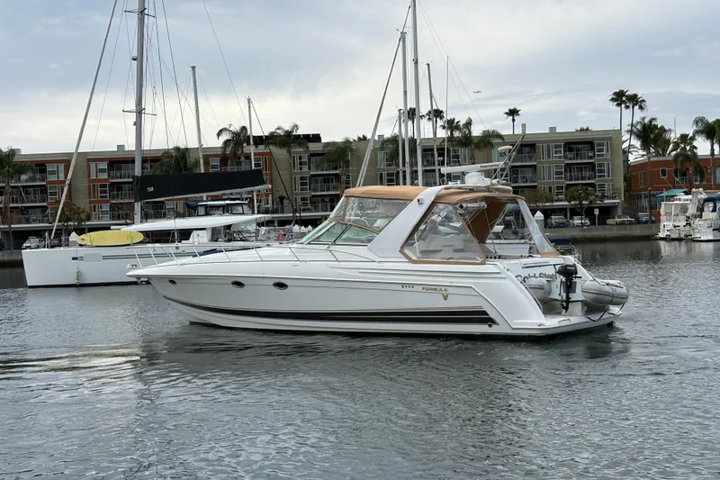 Slide: The Image of 2004 Formula 41 Performance Cruiser yacht docked in marina with modern buildings in background. - 38