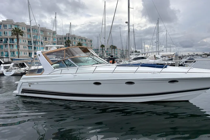 Slide: The Image of 2004 Formula 41 Performance Cruiser docked in a marina, surrounded by modern buildings. - 39