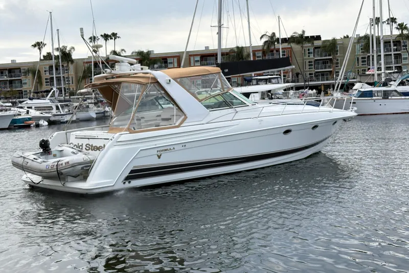 Slide: The Image of 2004 Formula 41 Performance Cruiser yacht docked in marina, surrounded by other boats. - 42