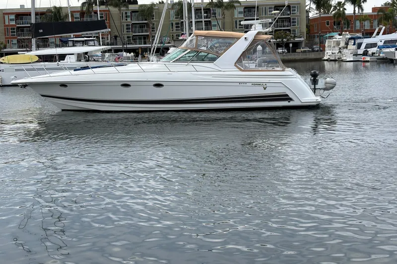 Slide: The Image of 2004 Formula 41 Performance Cruiser yacht docked in a marina, surrounded by water and boats. - 44