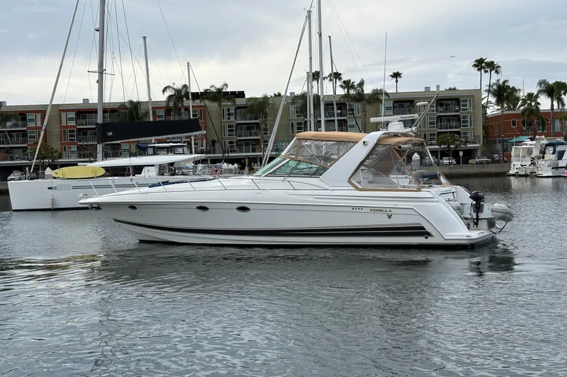 Slide: The Image of 2004 Formula 41 Performance Cruiser yacht docked in a marina with modern buildings. - 45