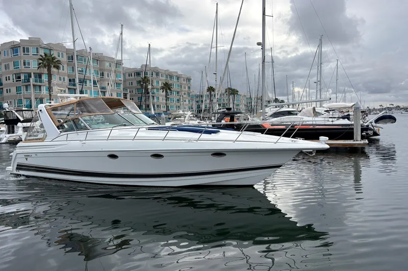 Slide: The Image of 2004 Formula 41 Performance Cruiser docked in a marina with modern buildings in the background. - 49