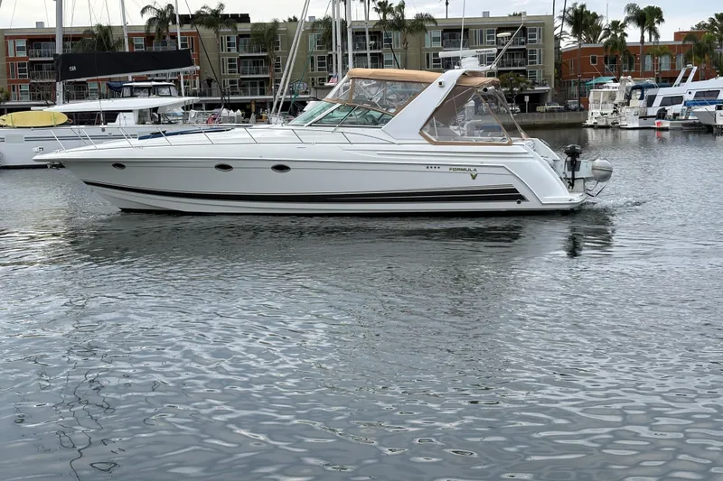 Slide: The Image of 2004 Formula 41 Performance Cruiser yacht docked in a marina, surrounded by water and buildings. - 52