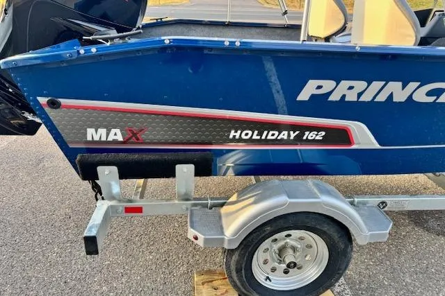 Slide: The Image of 2026 Princecraft Holiday 162 WS MAX boat on trailer, blue with red and silver accents. - 8