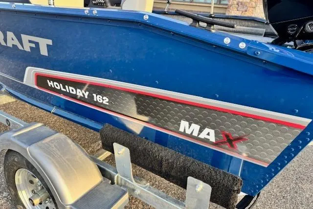 Slide: The Image of 2026 Princecraft Holiday 162 WS MAX boat on trailer, blue exterior with branding. - 9
