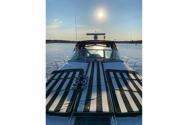 Slide: The Image of 2002 Sea Ray 380 Sundancer yacht with striped sun pads on deck at sunset. - 2