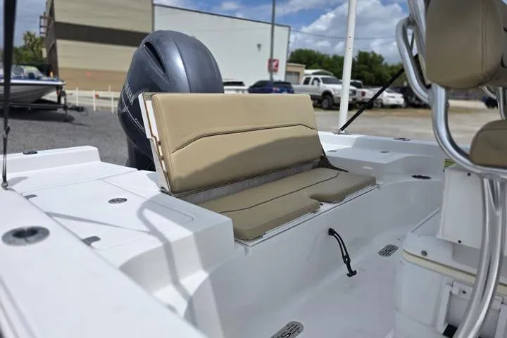 Slide: The Image of 2016 Sportmans Masters 227 Bay Boat interior with beige seating and motor. - 11