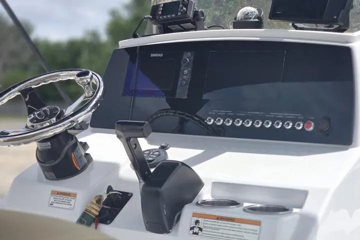 Slide: The Image of 2016 Sportmans Masters 227 Bay Boat dashboard with steering wheel and control panel. - 16