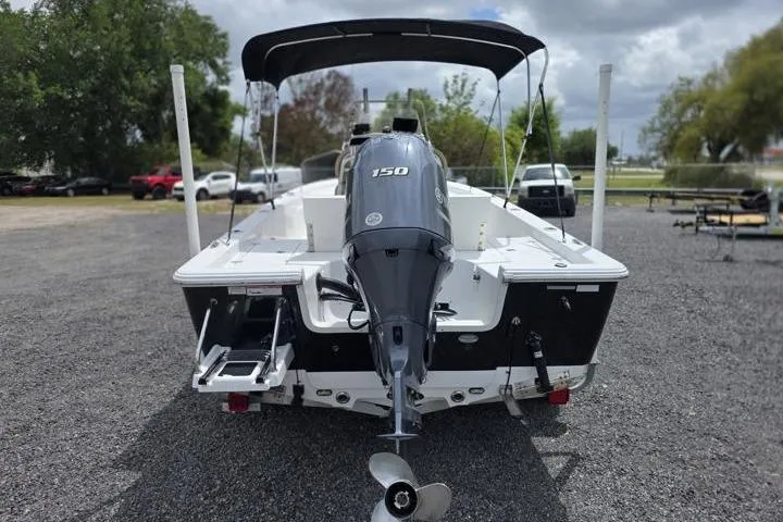 Slide: The Image of 2016 Sportmans Masters 227 Bay Boat with 150 HP engine, parked on gravel. - 4