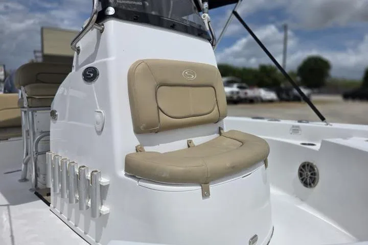 Slide: The Image of 2016 Sportmans Masters 227 Bay Boat with beige seating and rod holders, parked outdoors. - 9