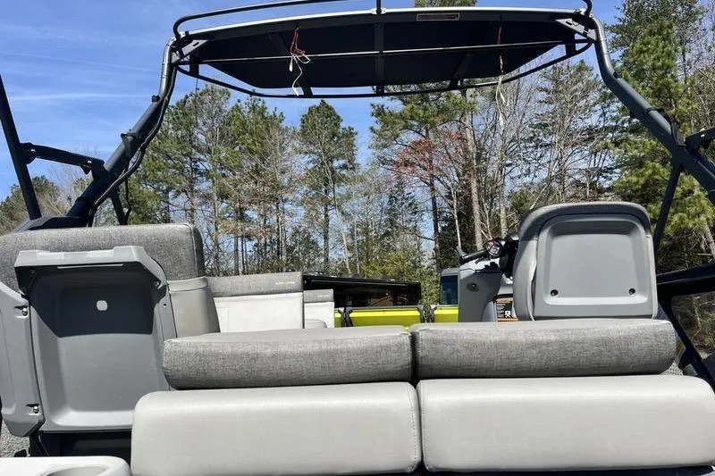 Slide: The Image of 2022 Sea-Doo Switch Cruise 21 interior with seating and canopy, surrounded by trees. - 11