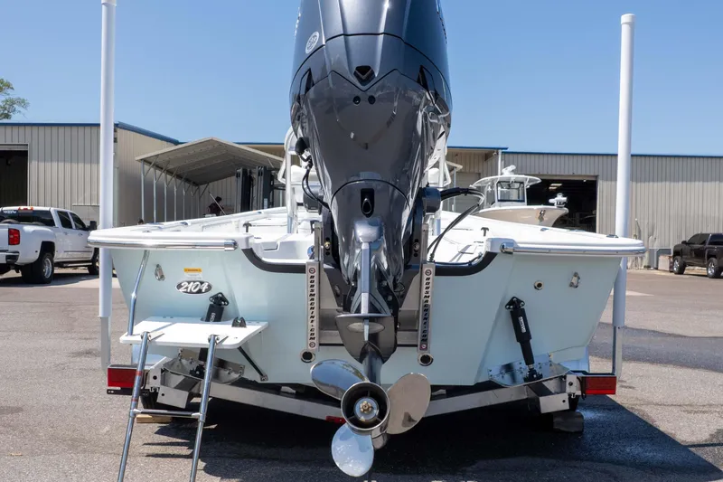Slide: The Image of 2025 Frontier 2104 boat with powerful outboard motor, parked at a marina. - 12