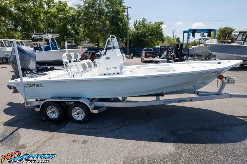 Slide: The Image of 2025 Frontier 2104 boat on trailer in marina, surrounded by other boats and trees. - 18