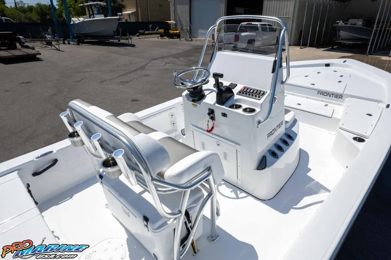 Slide: The Image of 2025 Frontier 2104 boat interior with steering console and seating, displayed outdoors. - 23