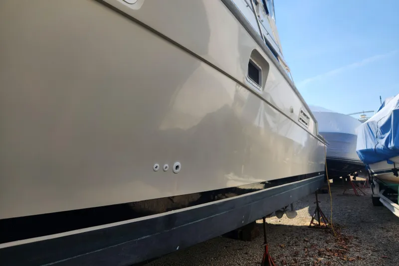 Slide: The Image of 1987 Luhrs 40 Convertible yacht on dry dock, side view under clear sky. - 29