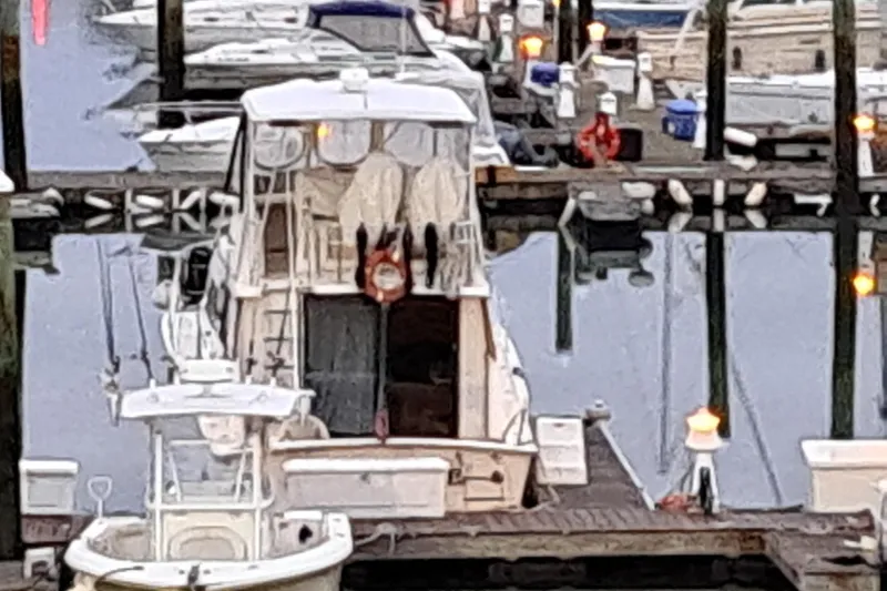 Slide: The Image of 1987 Luhrs 40 Convertible docked at marina with reflections on water. - 3
