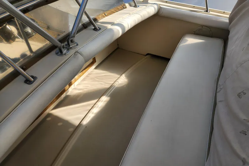 Slide: The Image of Interior seating area of a 1987 Luhrs 40 Convertible boat, featuring beige upholstery. - 31