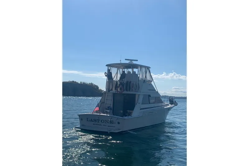 Slide: The Image of 1987 Luhrs 40 Convertible boat on water, sunny day, American flag displayed. - 4